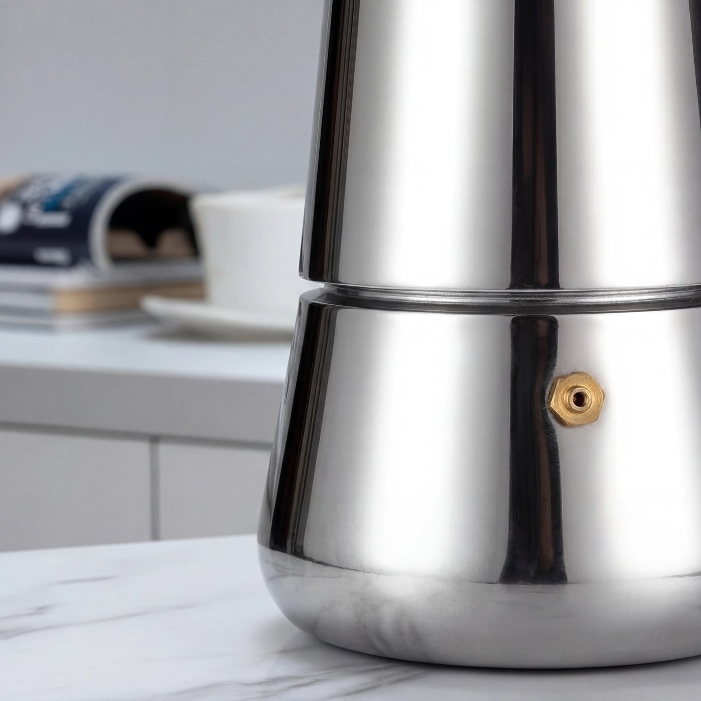 Gros plan de la soupape en laiton sur le corps en inox d'une cafetière italienne percolateur.