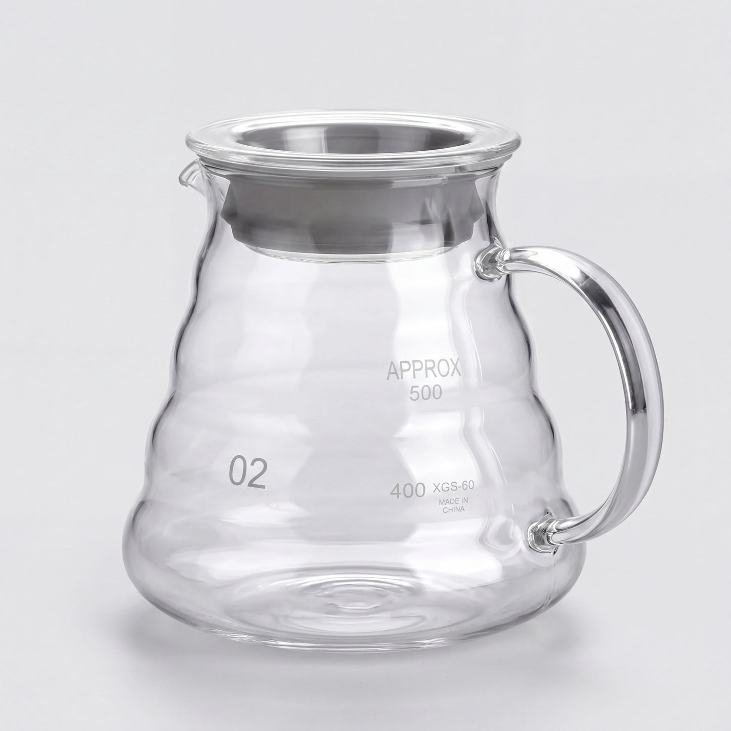 Carafe à café en verre borosilicate à anse en verre, vue de trois-quarts sur fond clair.