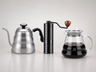 Kit Complet : bouilloire col de cygne en inox, moulin à café manuel et carafe en verre borosilicate, présentés ensemble sur fond clair.