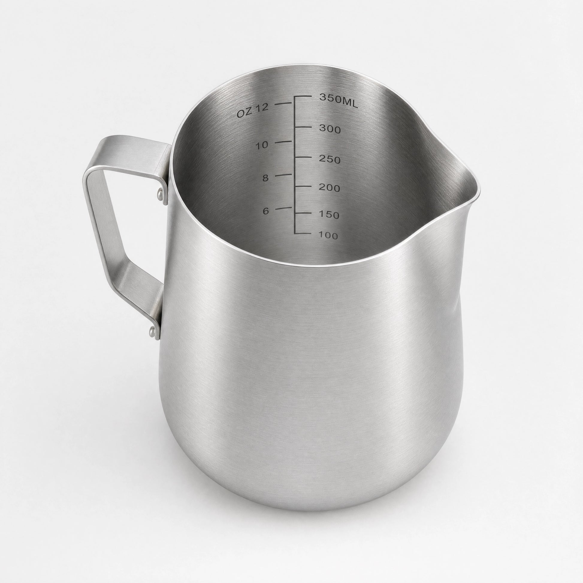 Pichet à lait en inox brossé vu de trois-quarts arrière, anse visible.