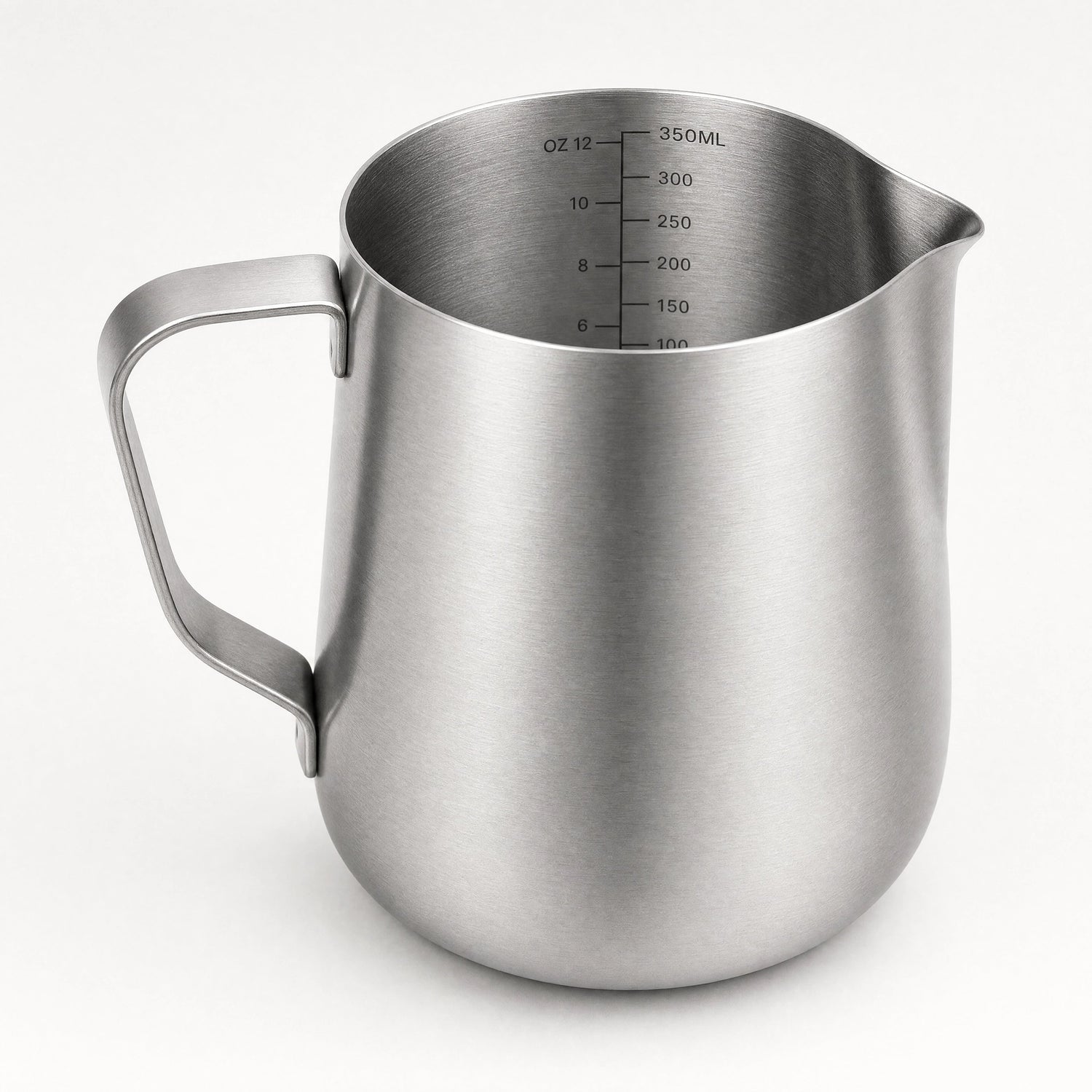 Pichet à lait barista en inox brossé avec graduation intérieure en millilitres et onces, bec verseur effilé, vue de trois-quarts.